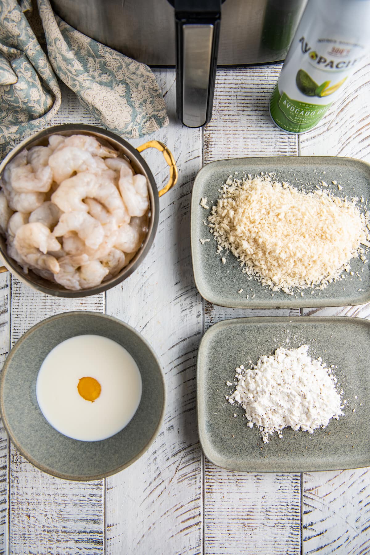 Ingredients for air fryer shrimp on gray plates and bowls.