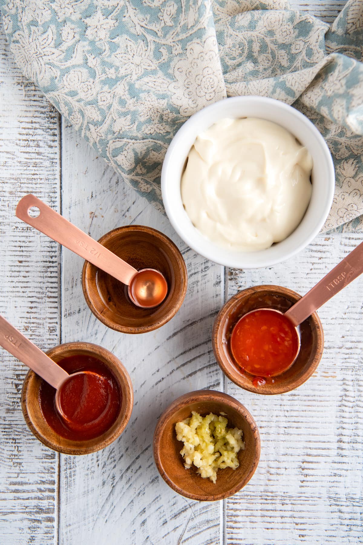 Ingredients for homemade sauce in wooden bowls on a white background.