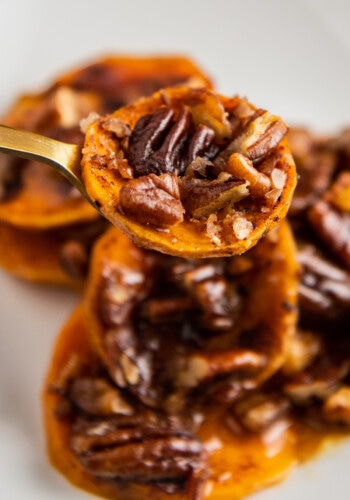 Candied sweet potato on a fork with pecans and brown sugar and cinnamon.