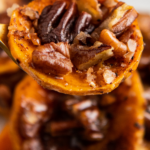 Candied sweet potatoes with pecans on a fork.