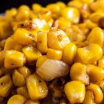 Up close image of sautéed corn with onion and seasonings.