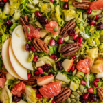 Overhead view of Shaved Brussel Sprout Salad with fresh citrus and apple slices on top.