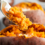 Sweet potato on a plate with a fork scooping up a bite.