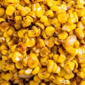 Overhead image of cooked corn with onions in a bowl.
