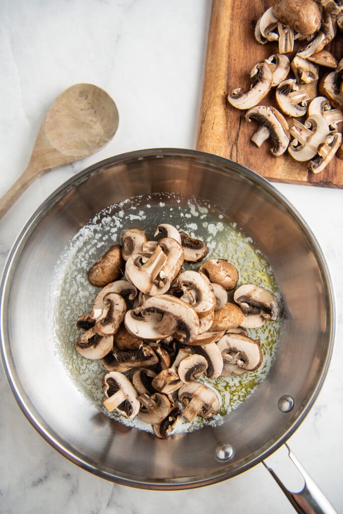 Mushrooms in butter and olive oil in a skillet.