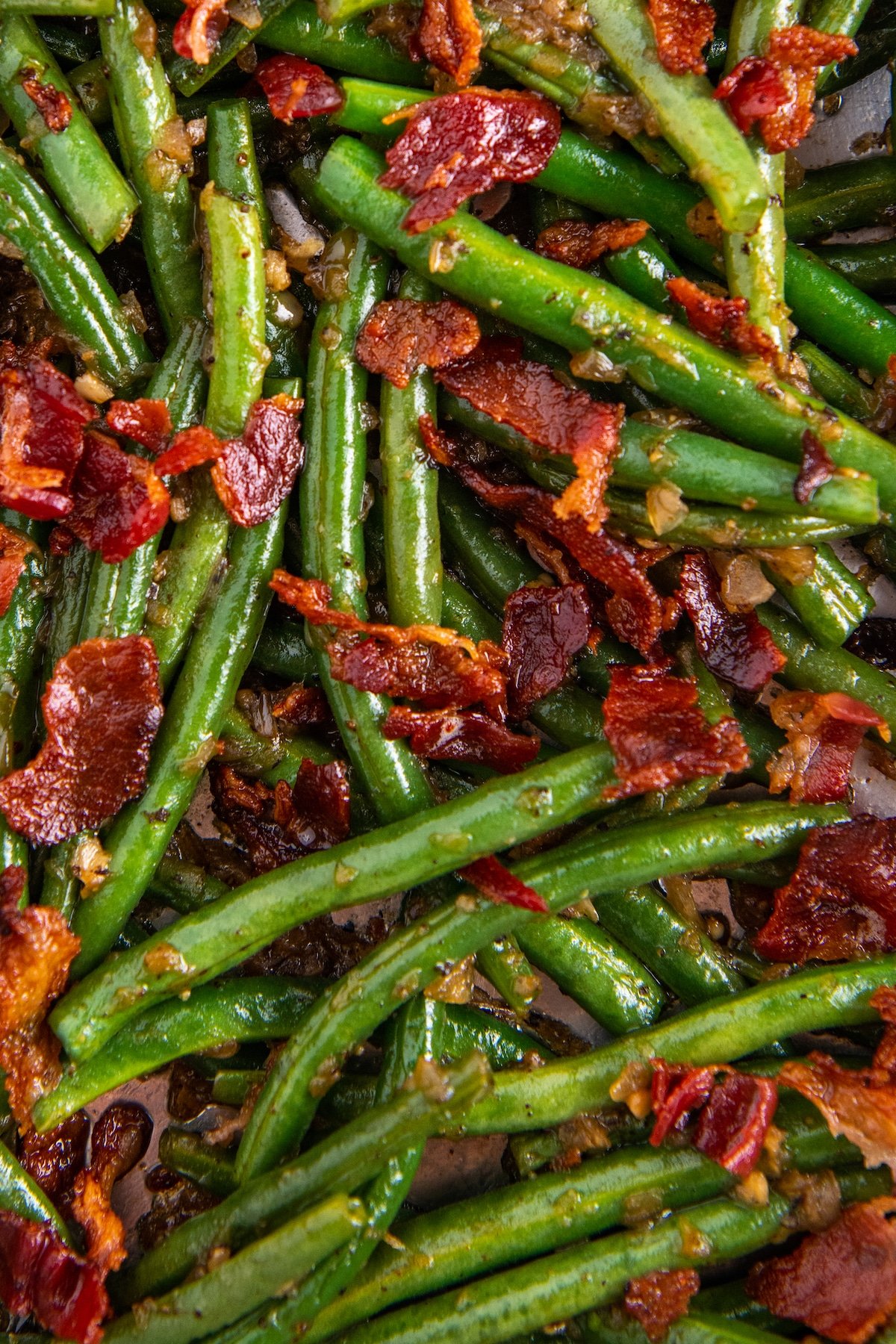 Sautéed green beans with fried bacon on top.