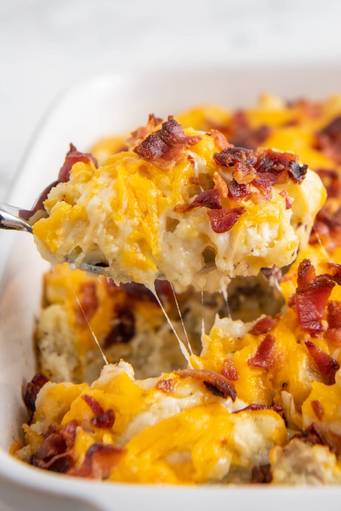 Up close image of twice baked potato casserole being scooped out with a spoon.