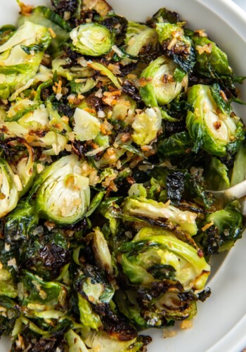 A bowl filled with air fried Brussel sprouts with a fork.