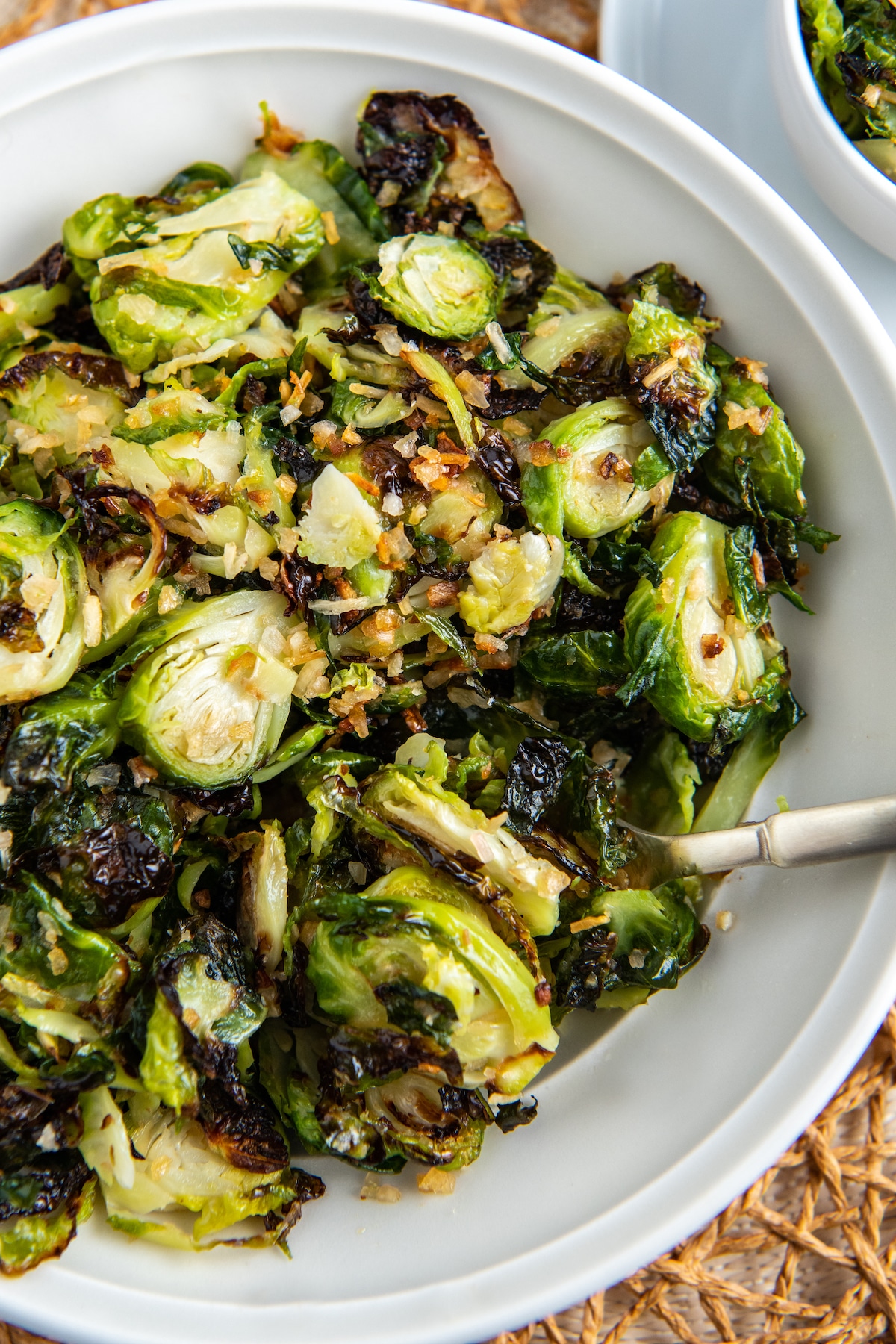 Air fryer Brussels sprouts on a white plate with a fork.