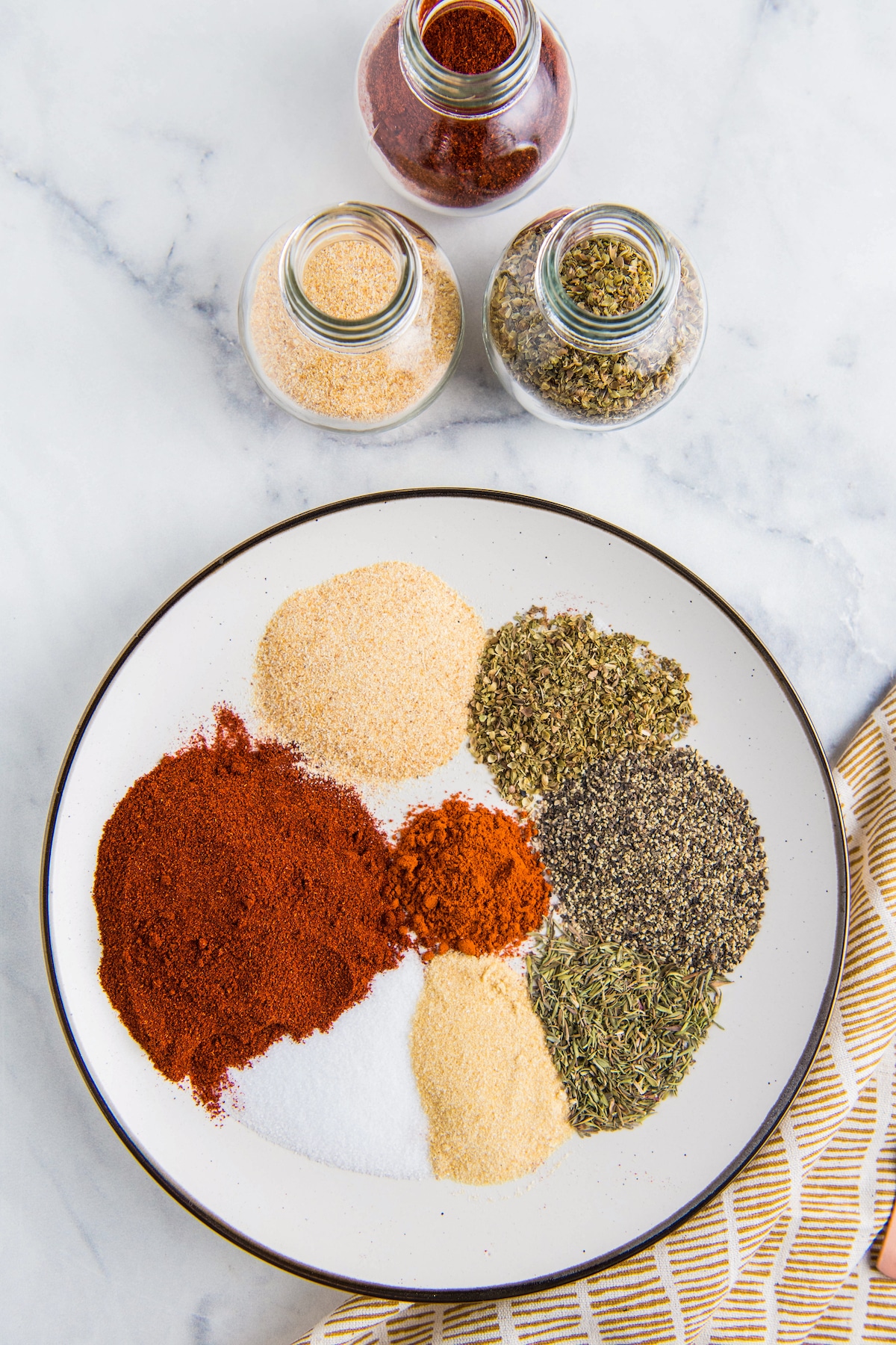 A plate filled with different seasonings with a tea towel.