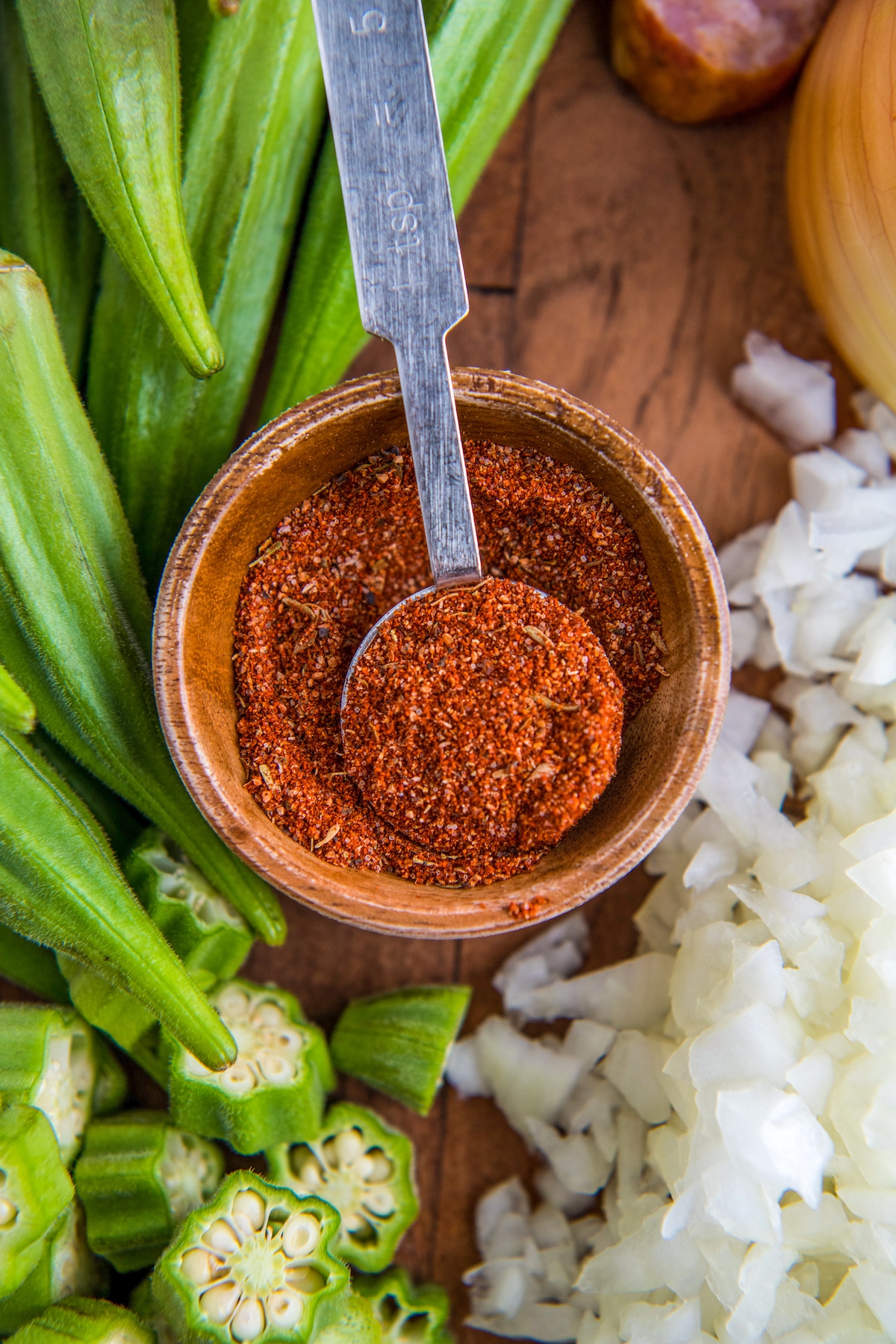 Cajun seasoning in a wooden bowl with a spoon.