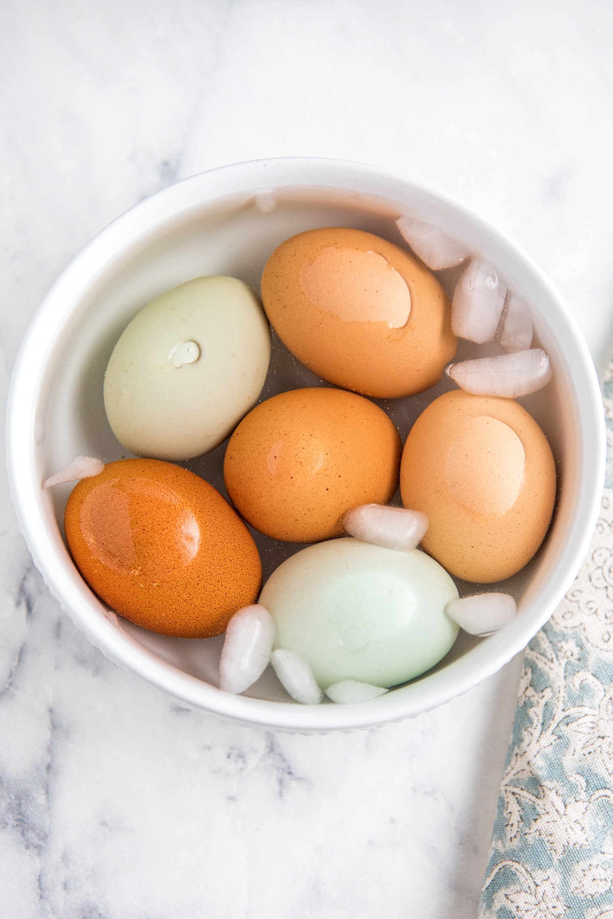 Eggs in an ice bath in a white bowl.