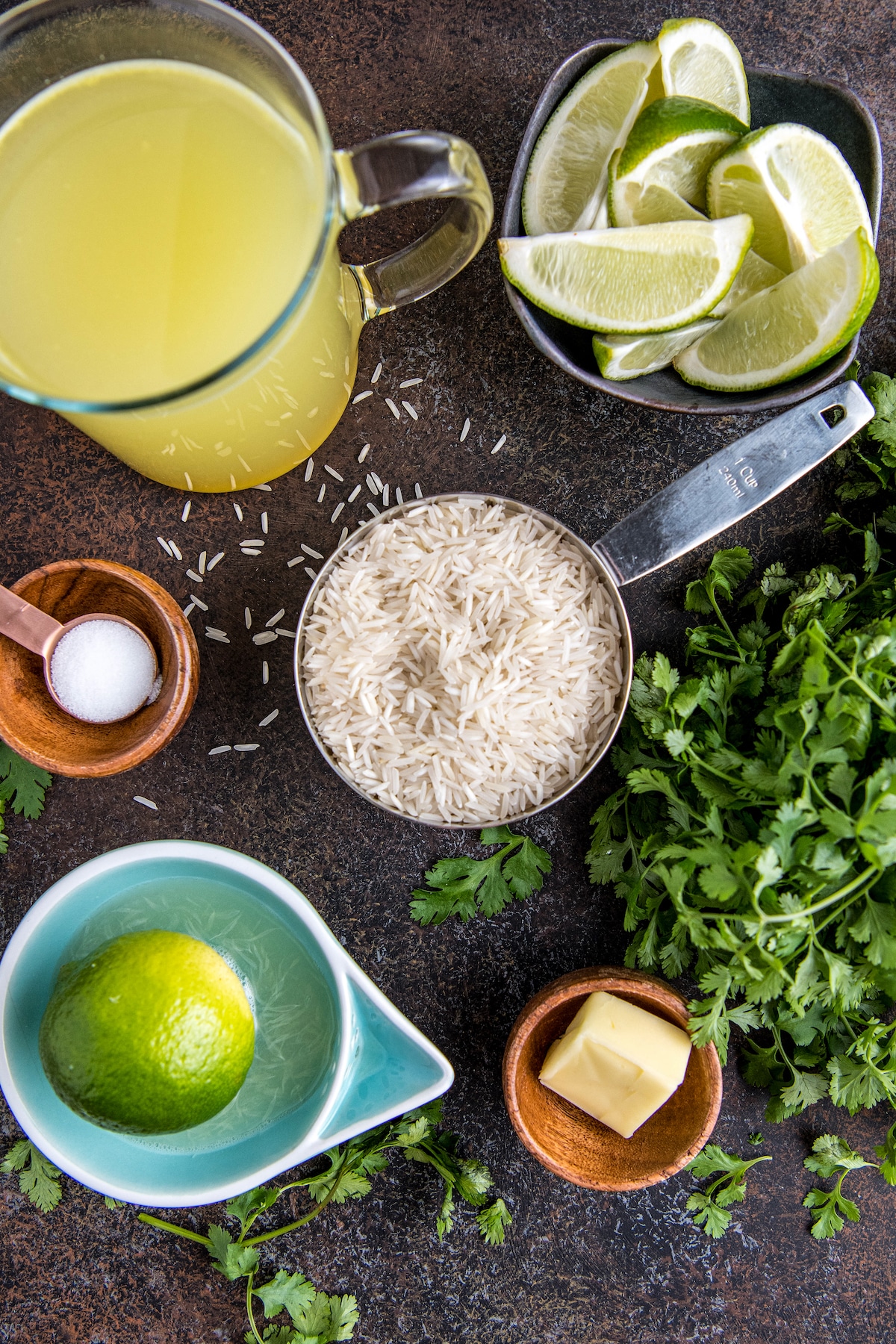 Ingredients for rice arranged in bowls with cilantro scattered around.