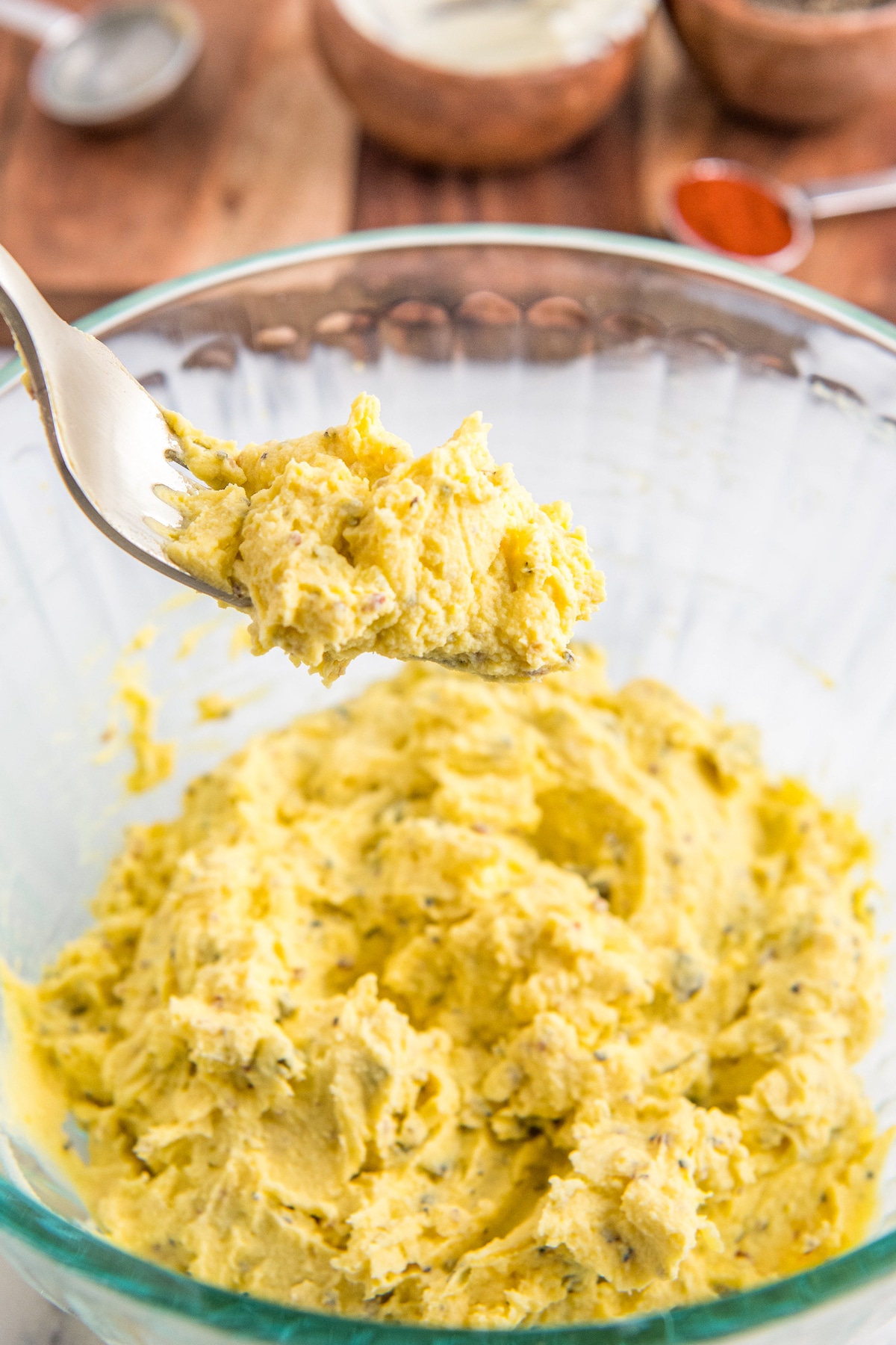 Filling of mashed egg yolks, relish, mayo and seasonings all mixed together in a bowl with a fork.