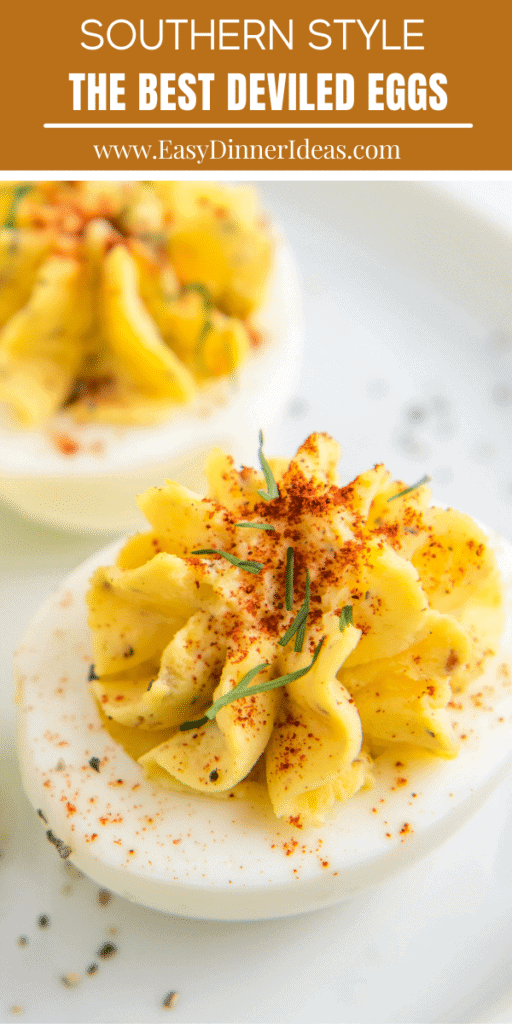 A deviled egg with smoked paprika and chives on top.