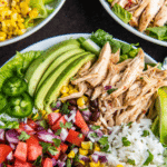 Three chicken burrito bowls in white bowls with a tea towel.