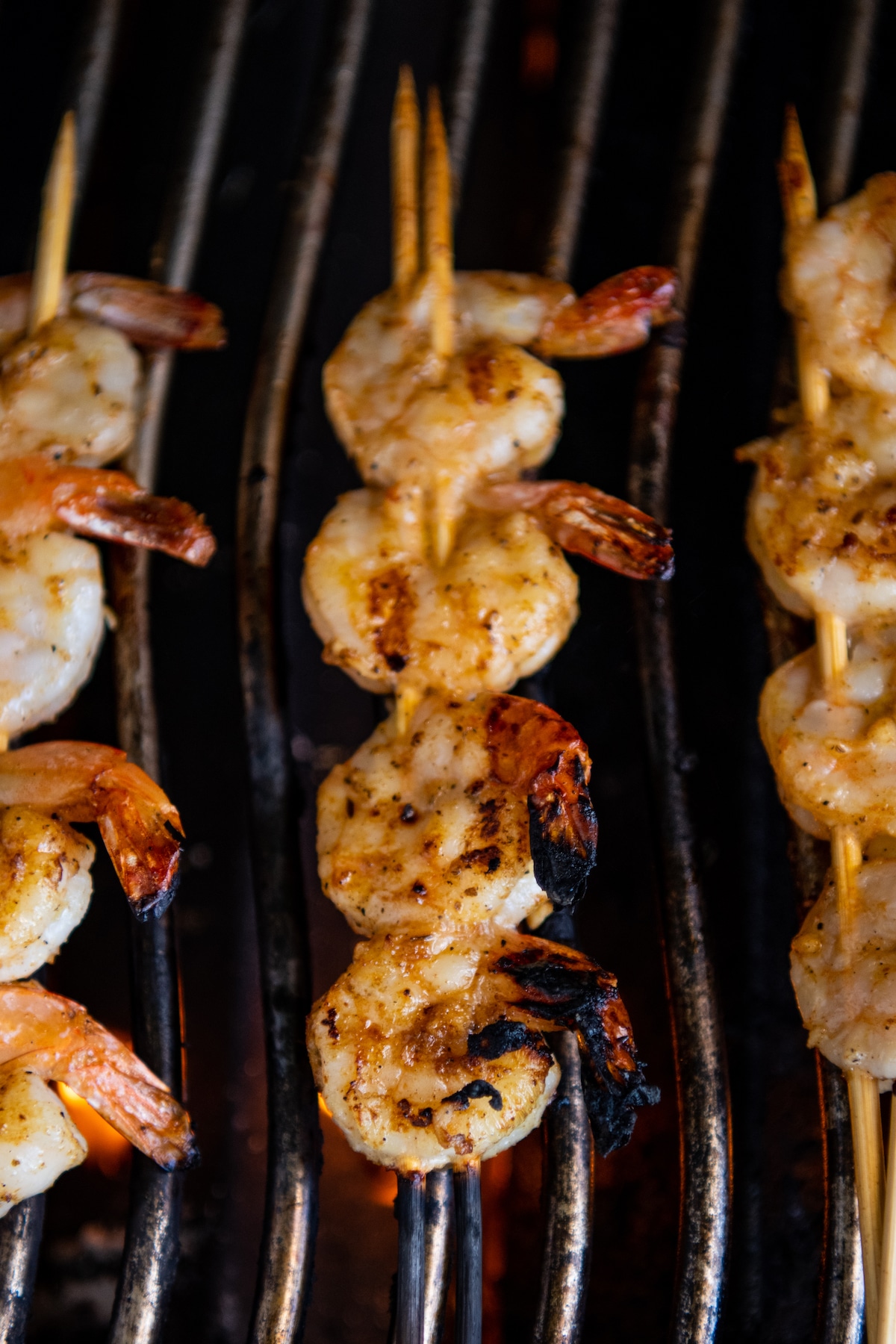 Cooked shrimp pan skewers on a grill.