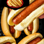 Hot dogs in an air fryer basket with one hot dog being picked up.