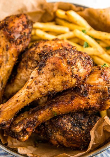 Up close image of baked chicken legs stacked on top of each other.