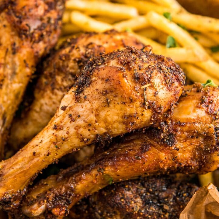 Up close image of baked chicken legs stacked on top of each other.