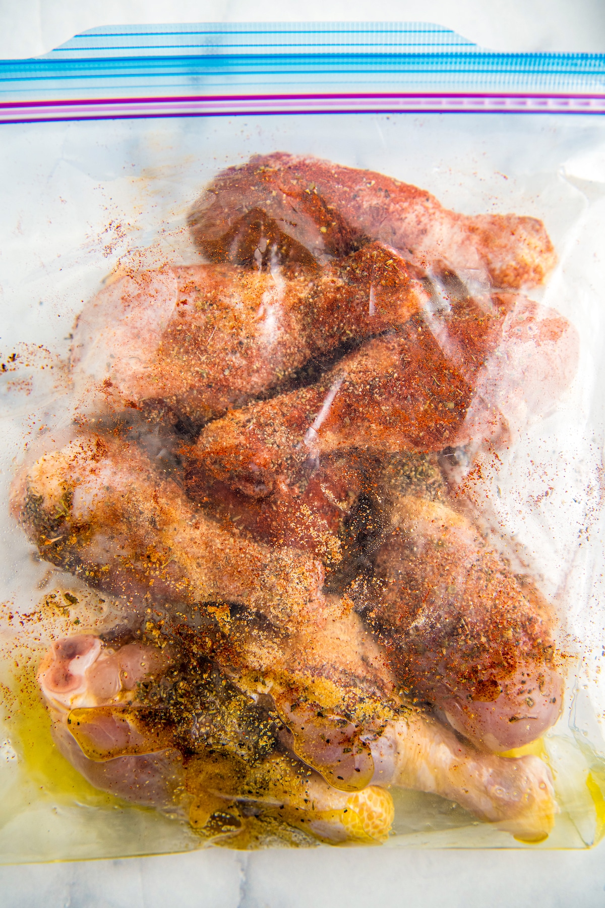 Chicken legs in a ziplock bag with seasonings.