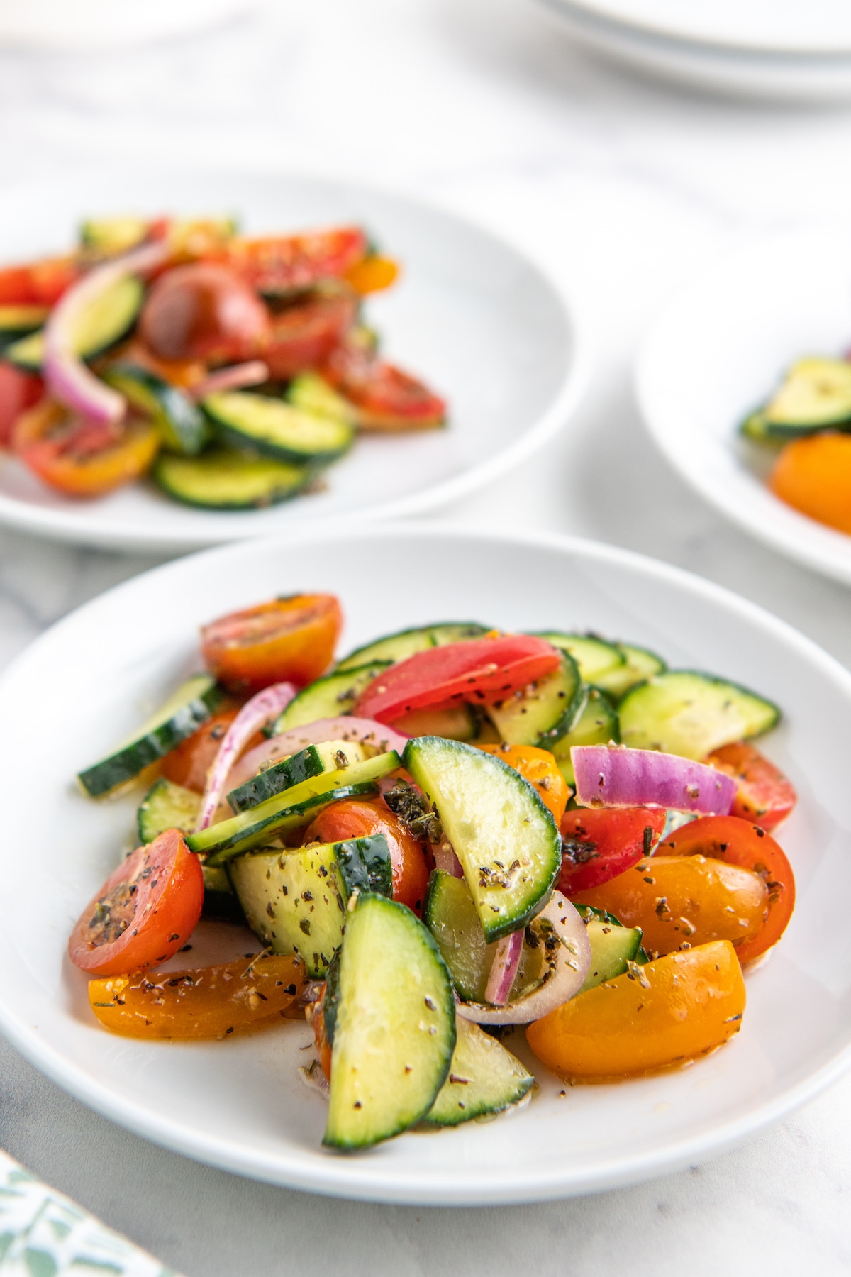 Tomato and cucumber salad on a white plate.