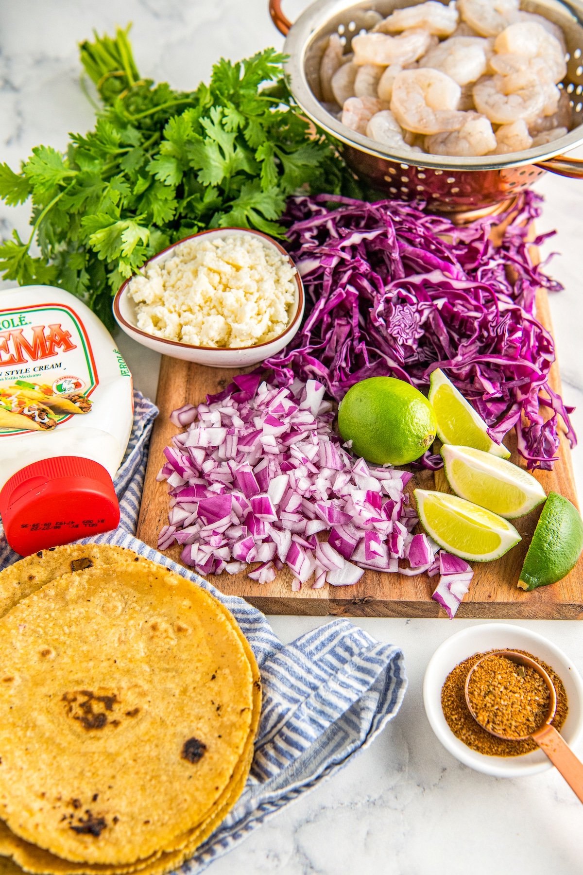Ingredients for tacos arranged on a cutting board and in bowls.