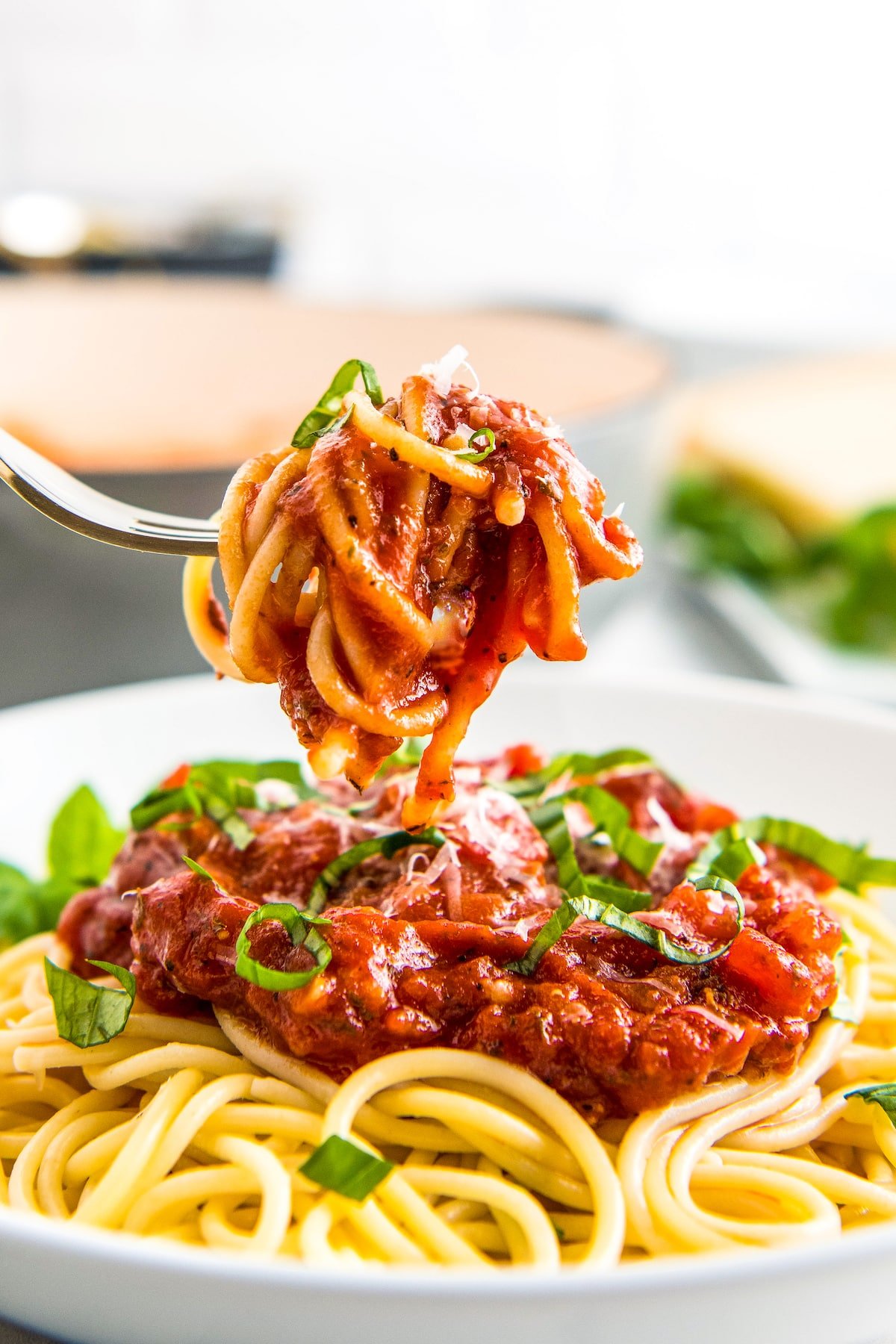 A forkful of spaghetti covered in marinara sauce.