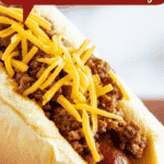 A hot dog with chili and cheese on it.