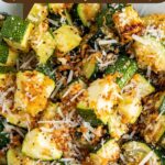 A bowl of crispy air fryer zucchini with parmesan cheese on top.