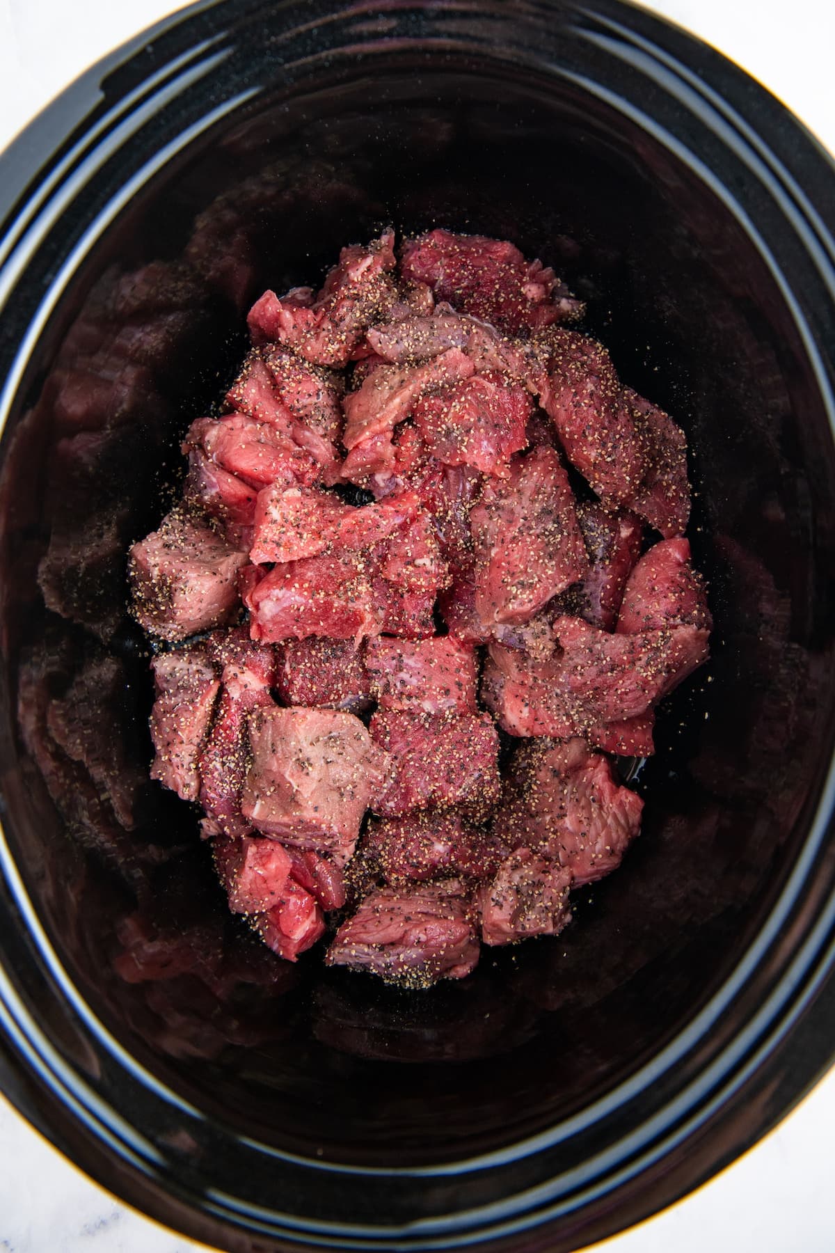 Cut up beef in a crockpot with salt and pepper on top.