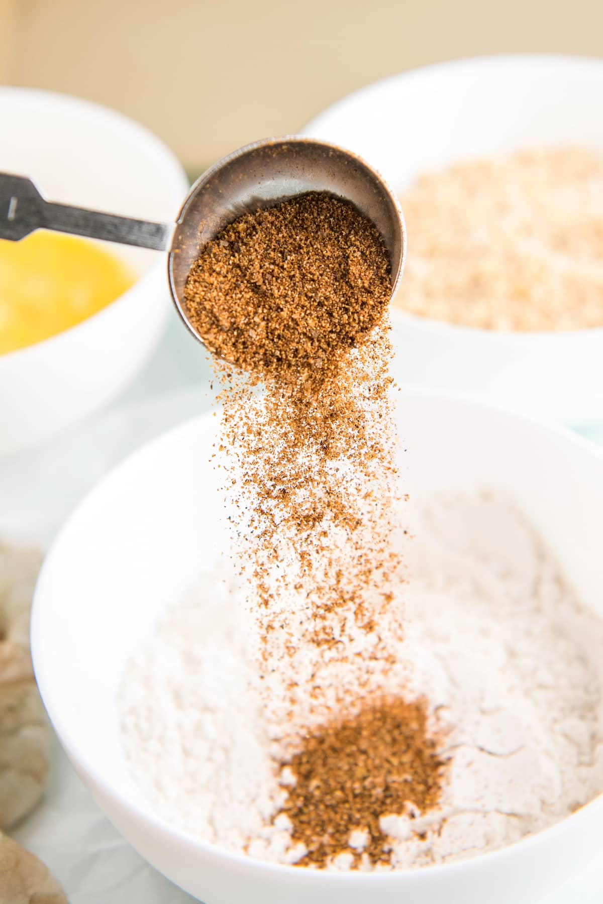 Cajun Seasoning being poured into a bowl of flour.