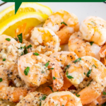Garlic butter shrimp on a plate with lemon wedges.