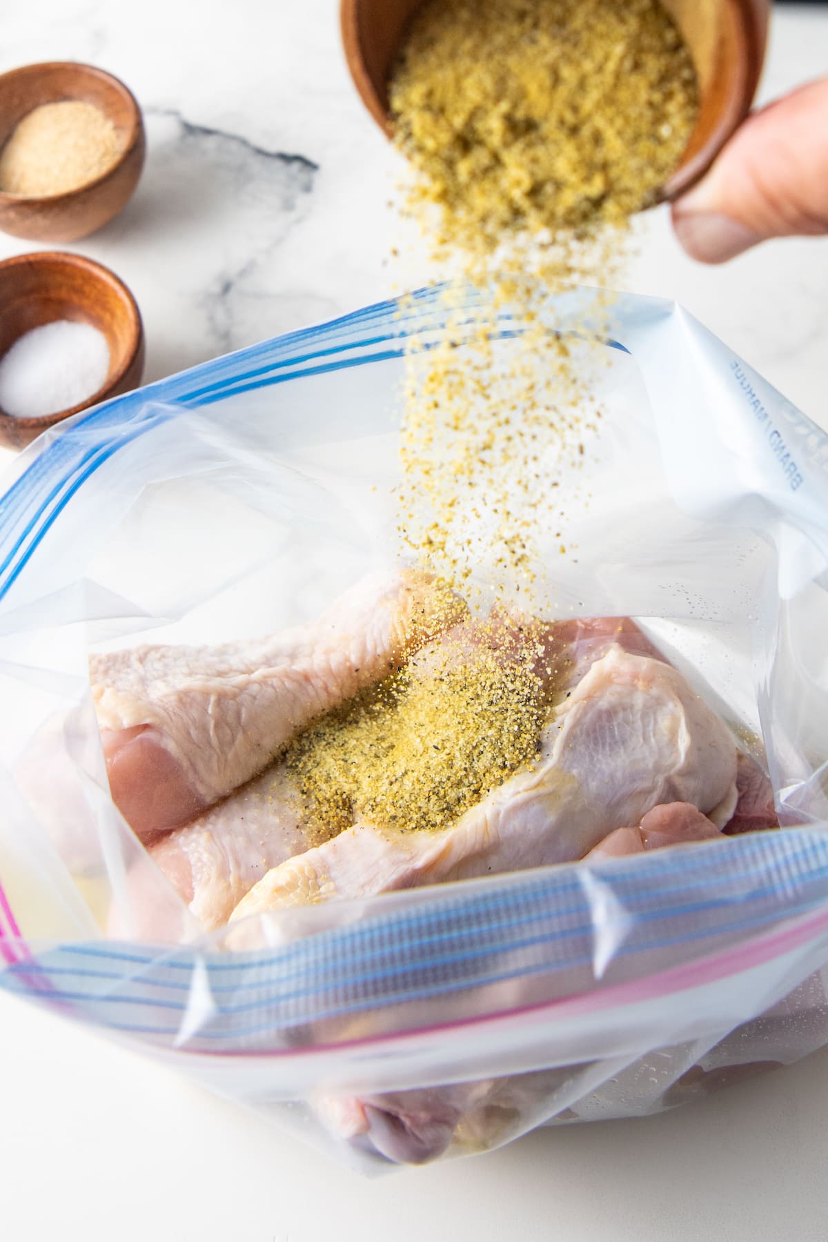 seasoning chicken drumsticks in a plastic bag