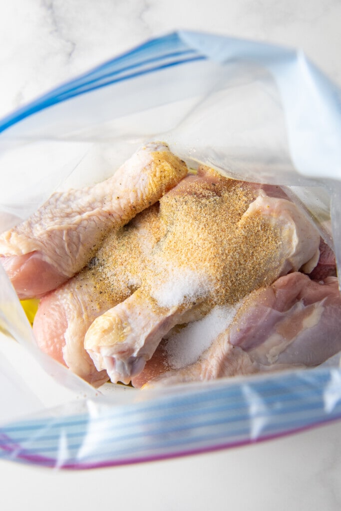 seasonings on chicken drumsticks in a plastic bag
