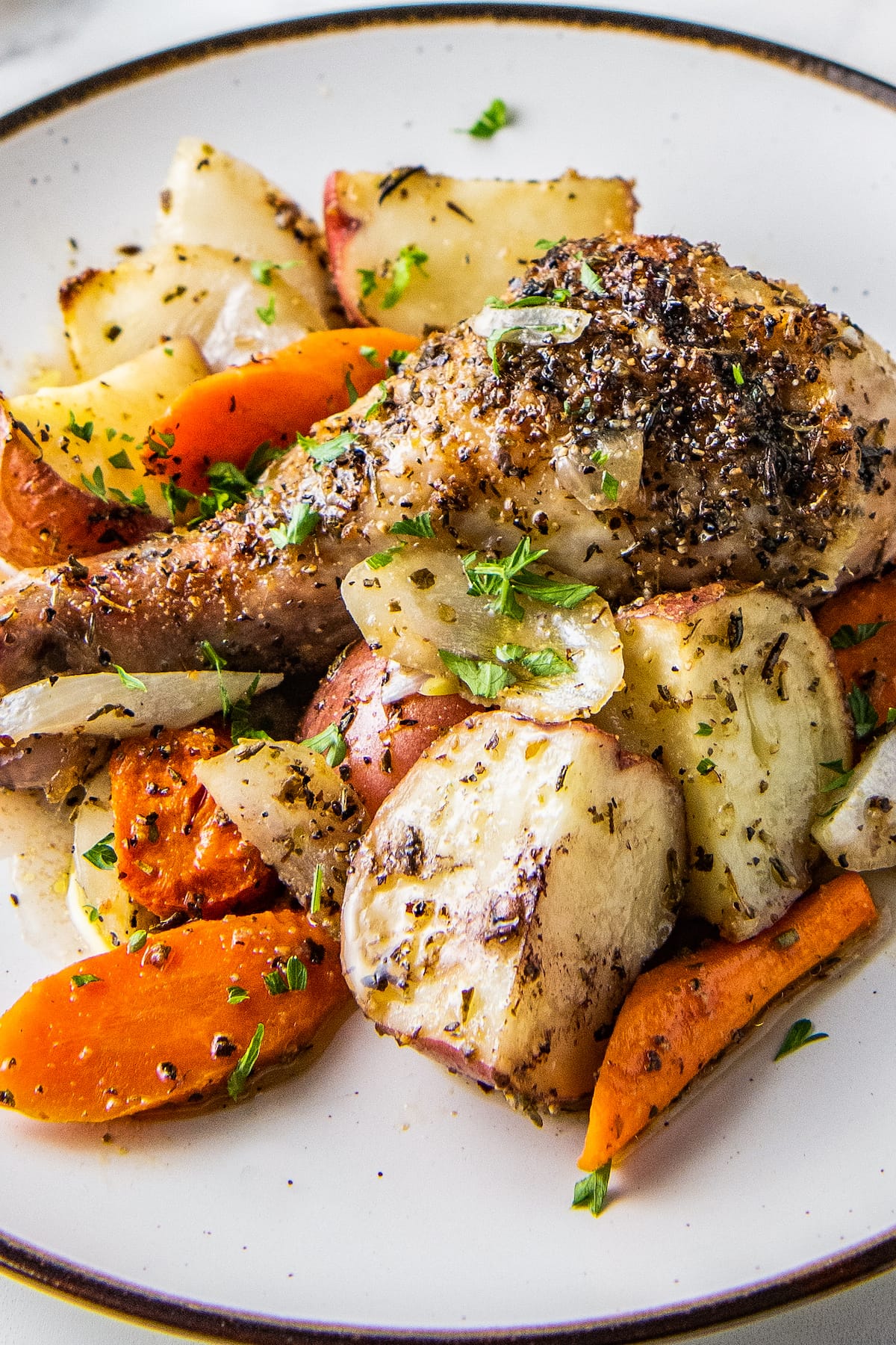 close up of cooked chicken legs and vegetables