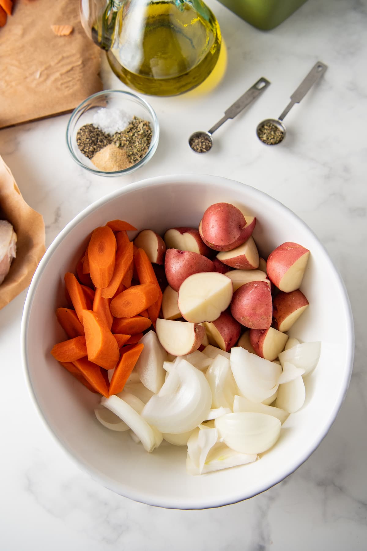 a bowl with chopped carrots, potatoes, and onions