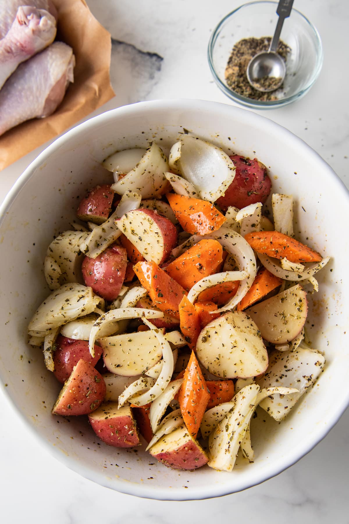 a bowl with large cuts of assorted vegetbles like carrots, onions, and potatoes