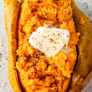 close up of a baked sweet potato with butter, salt, and pepper