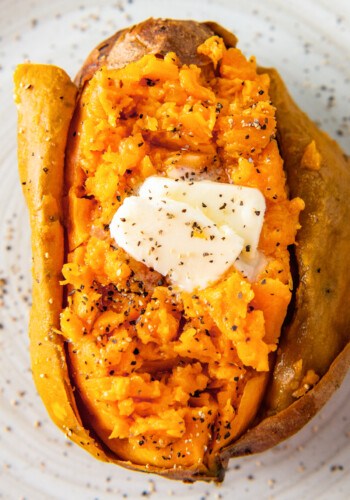 close up of a baked sweet potato with butter, salt, and pepper