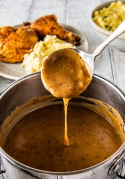 a saucepot with gravy and a small spoon covered in the gravy