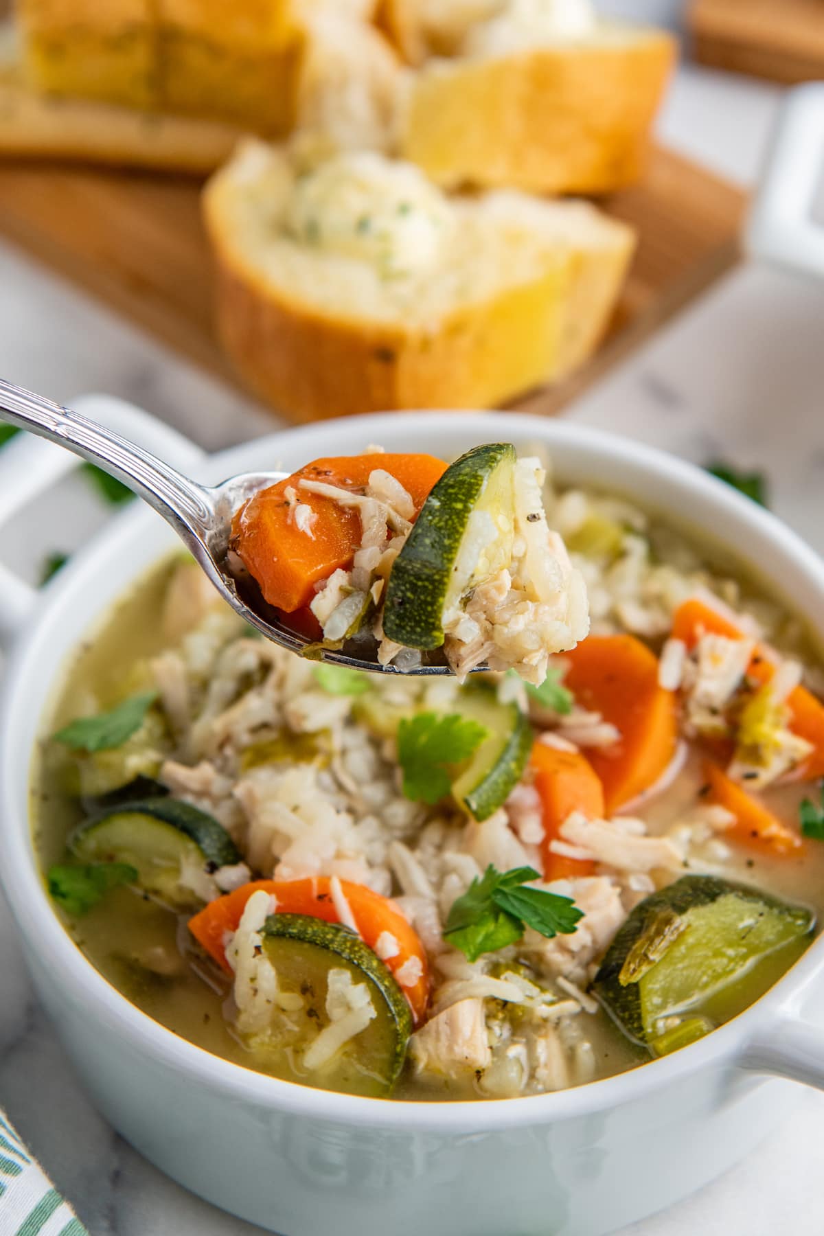 close up of a spoonful of rice and chicken soup