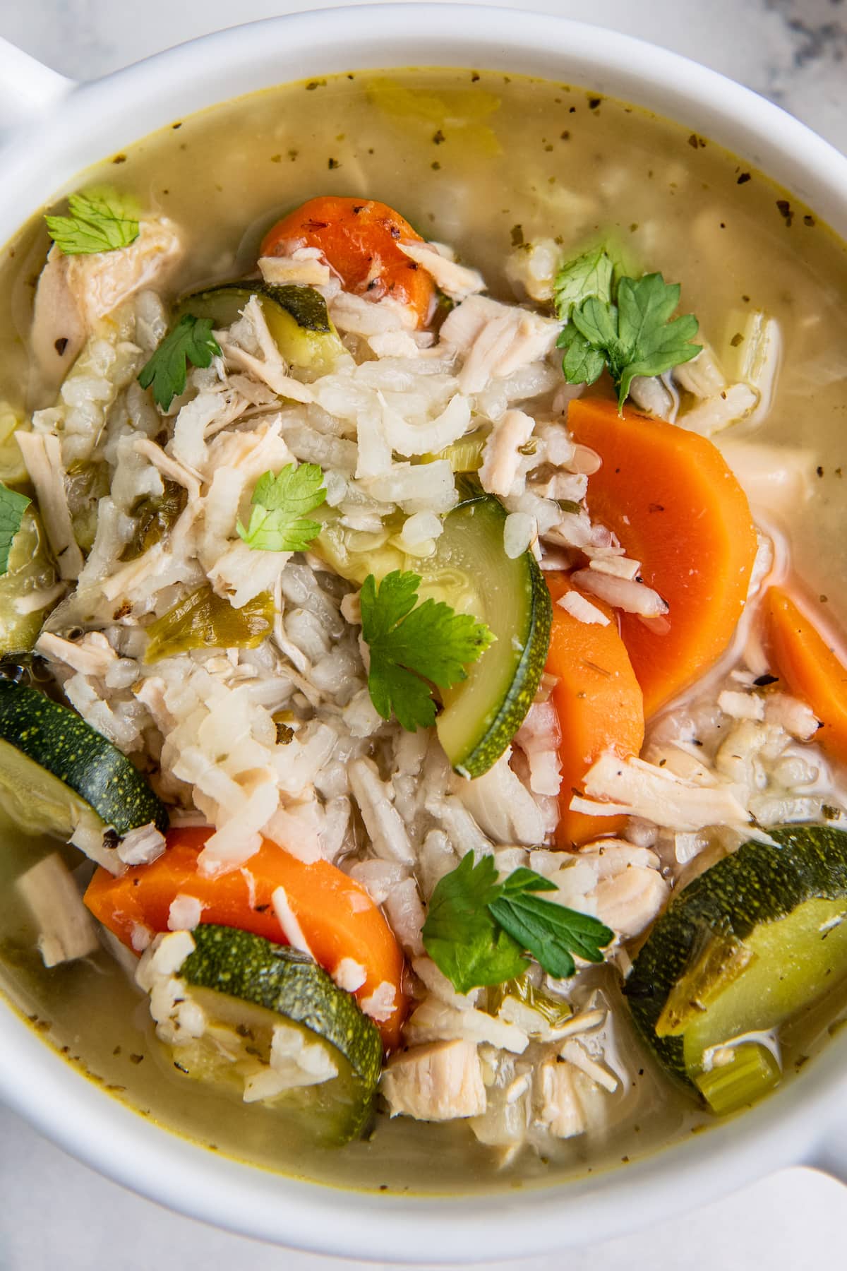 close up of a spoonful of rice and chicken soup