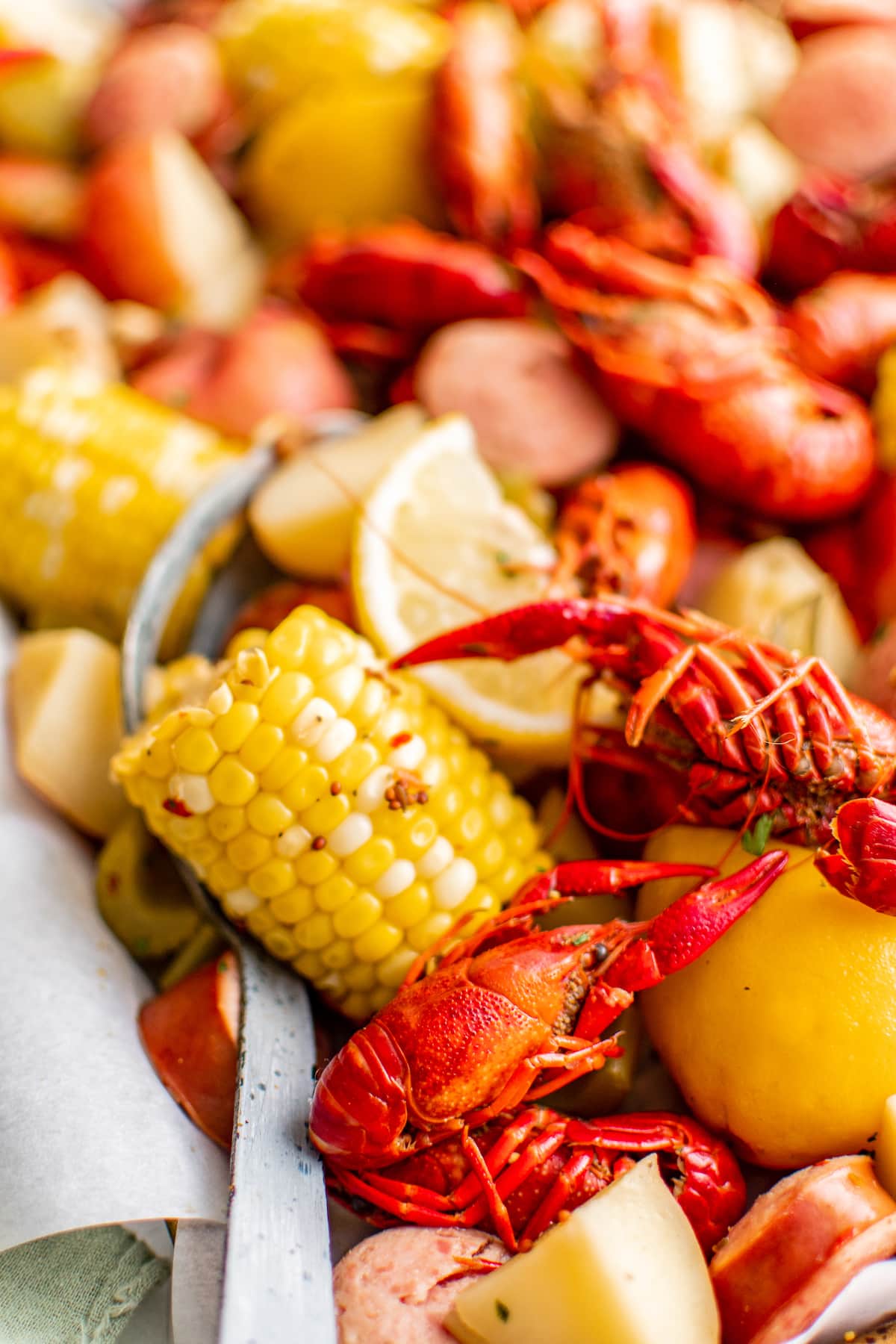 Boiled crawfish with potatoes, sausage and corn on a sheet pan.
