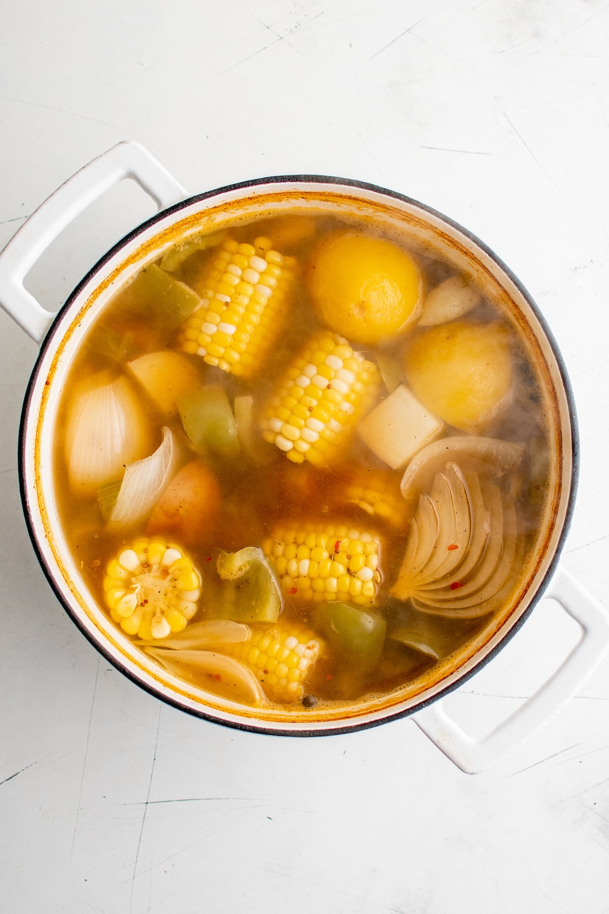 Broth and vegetables in a white pot.