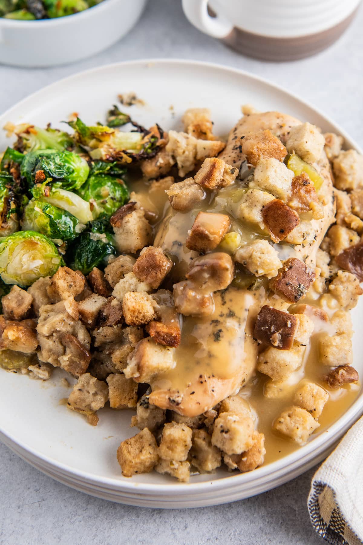 a plate of crockpot chicken and stuffing with a side of brussels sprouts