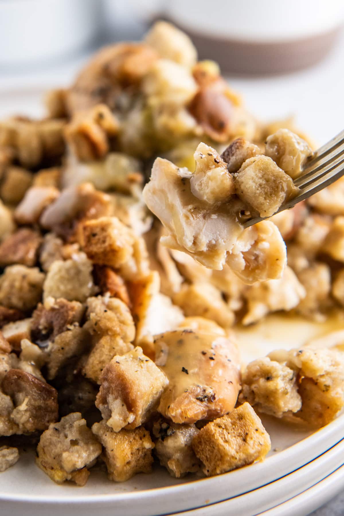 a bite of chicken with stuffing being taken off of a plate