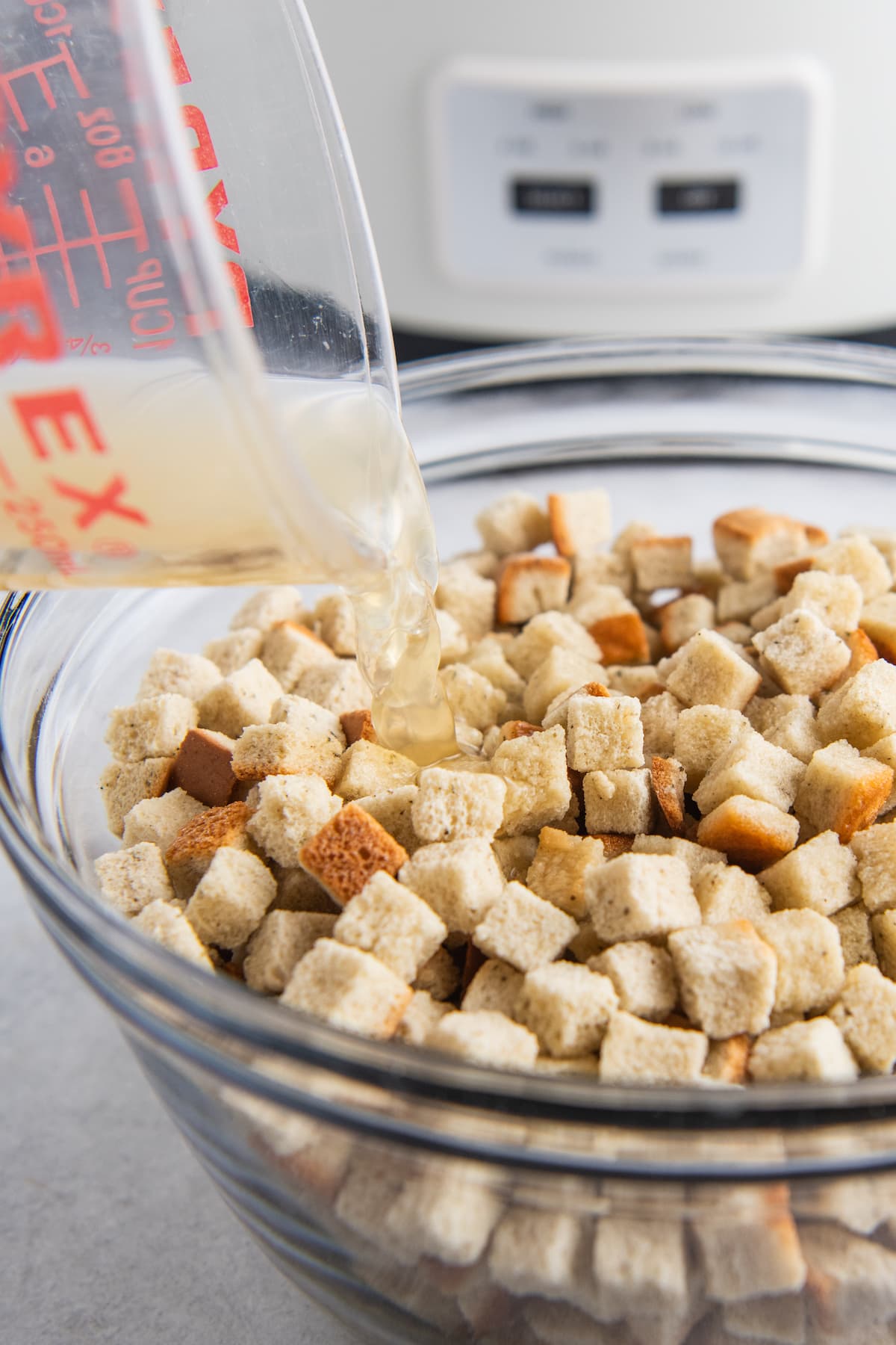 pouring stock into a bowl of dried stuffing mix