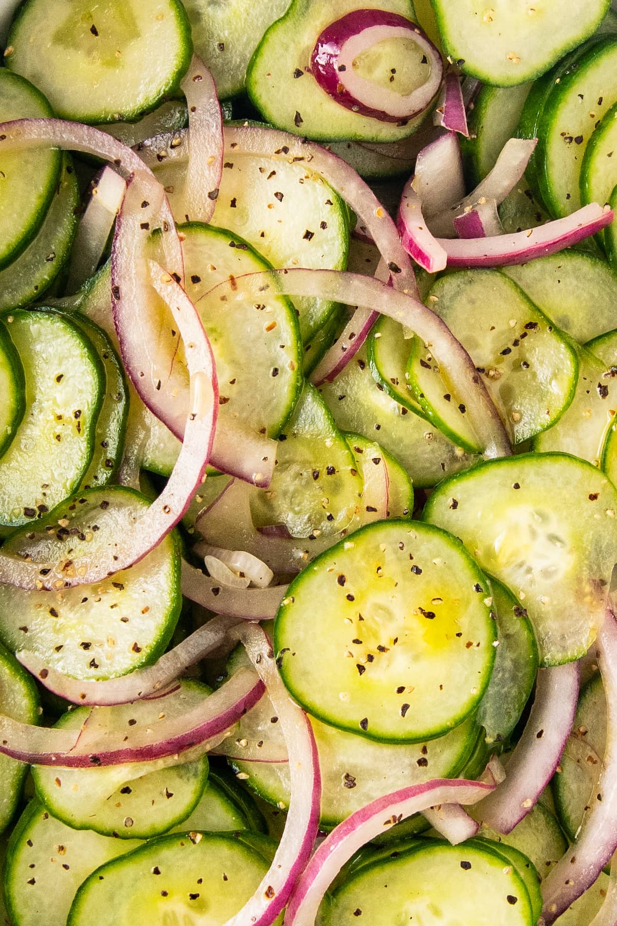 Cucumber salad with onions topped with salt and pepper.