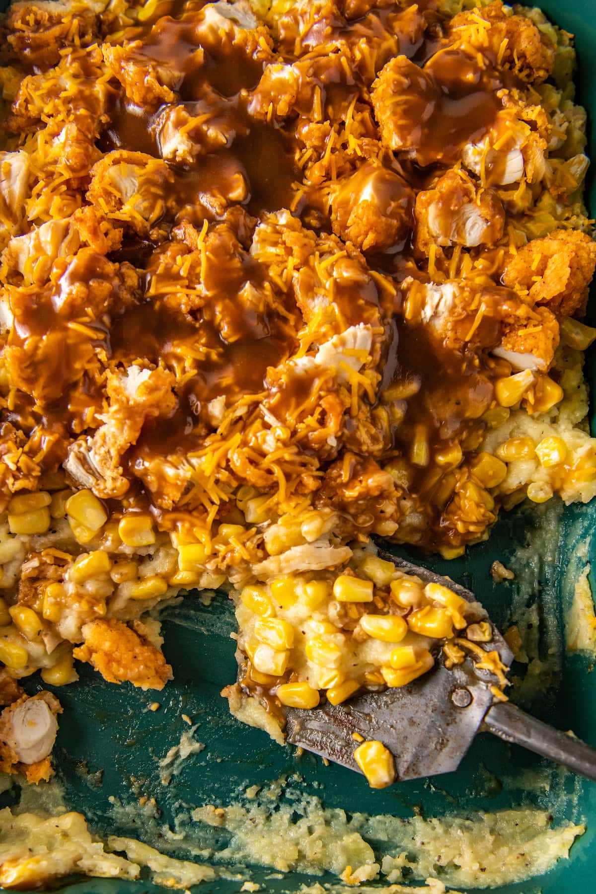 scooping chicken casserole out of a baking dish